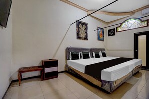 A bedroom with a bed, a nightstand, and a door. - Hotel O near City of Tomorrow Mall formerly Vandhela Homestay (Surabaya)