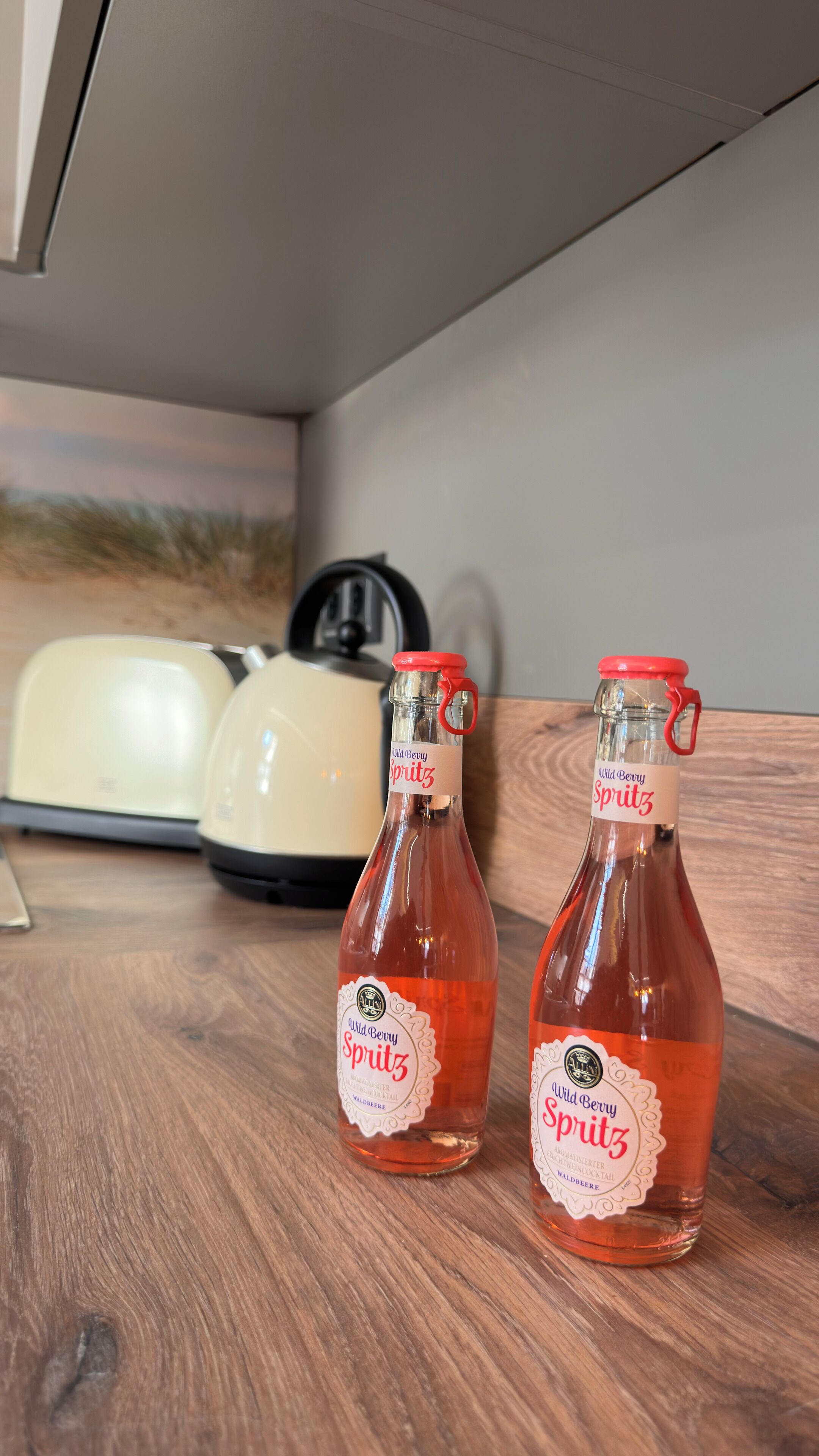 Dos botellas de Wild Berry Spritz sobre una superficie de madera.