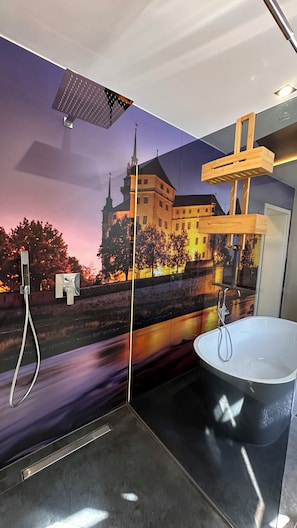 A bathroom with a large bathtub, a shower, and a wall mural of a building. - Historic downtown apartment with a game room, air conditioning, and a balcony in Torgau (Torgau)