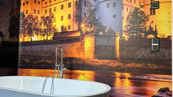 A bathroom with a bathtub, a shower, and a large mirror.