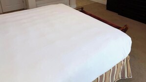 Makuuhuone, jossa on sänky, kylpyamme, peili ja televisio.