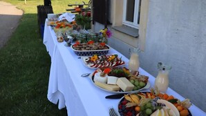 Una mesa al aire libre con diversos alimentos y bebidas.