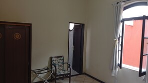 A room with a chair, a door, and a window with curtains. - Direita S.Antonio -Comfort quarter and hall, view centro historico. (Salvador)