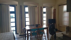 A dining area with a table, chairs, a television, and a fan. - Direita S.Antonio -Comfort quarter and hall, view centro historico. (Salvador)