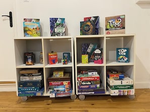 A shelf with various board games and puzzles.