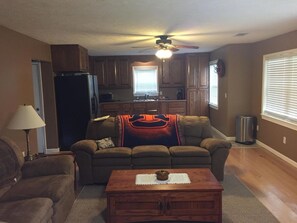 A living room with a sofa, a coffee table, and a ceiling fan.