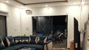 Un salon moderne avec un canapé d’angle, une table basse et un téléviseur.