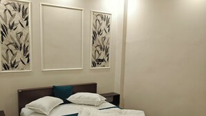 Une chambre à coucher avec un lit, des tables de chevet et des œuvres d’art murales.