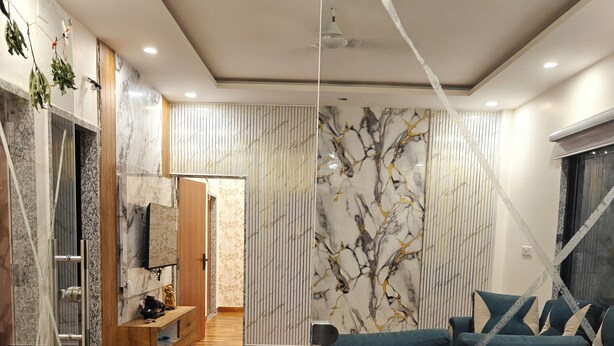 Un salon moderne avec un plancher en bois, un canapé, un téléviseur et un mur décoré d’un motif.