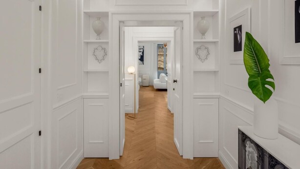 A hallway with white walls, wooden flooring, and decorative heart-shaped wall art. - Carla, elegant and romantic studio suite on the 2nd floor in the city of Noto (NOTO)