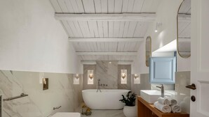 A modern bathroom with a freestanding bathtub, a toilet, and a vanity with a mirror. - Carla, elegant and romantic studio suite on the 2nd floor in the city of Noto (NOTO)