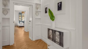 A hallway with white walls, a wooden floor, and a white door leading to another room. - Laura, elegant 1st floor suite with terrace: open-air relaxation in the center of Noto (NOTO)