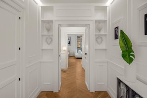 Een hal met witte wanden, houten vloeren en decoratieve hartvormige decoratie.