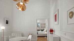A modern interior with a dining area, a sofa, and a hallway leading to a bedroom. - Laura, elegant 1st floor suite with terrace: open-air relaxation in the center of Noto (NOTO)