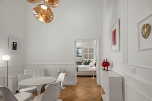 Een modern interieur met een eethoek, een bank en een gang naar een slaapkamer.
