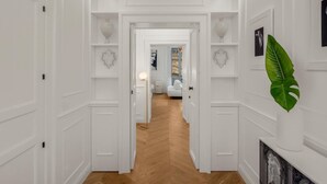 Un pasillo con paredes blancas, suelo de madera y decoración con forma de corazón en la pared.
