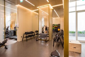 Ein Fitnessstudio mit Laufbändern, Kurzhanteln und Trainingsgeräten.