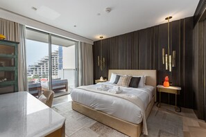 Et moderne hotelværelse med en stor seng, et skrivebord og udsigt over bybilledet.