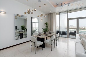 Un espace repas moderne comprenant une table, des chaises et un grand miroir.