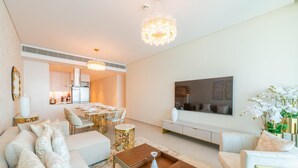 A modern living room with a sofa, coffee table, and a dining area in the background. - Gorgeous Apt wz Stunning Sea Views in Address JBR (Dubai)