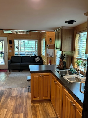 A compact kitchen with wooden cabinets, a black countertop, and a sink. - Cozy Woodland Escape in Hoodsport near Lake Kokanee and Olympic Hiking (Hoodsport)