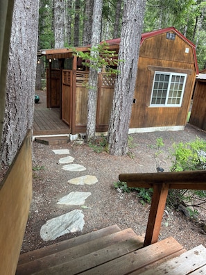 A wooden cabin with a stone pathway leading to a deck, surrounded by tall trees. - Cozy Woodland Escape in Hoodsport near Lake Kokanee and Olympic Hiking (Hoodsport)
