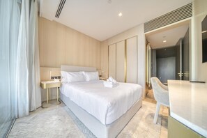 A modern hotel room with a large bed, bedside tables, a desk, and a chair. - Modern Sea View Apt. at the FIVE Palm Jumeirah (Dubai)
