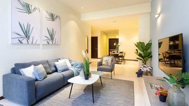 Ein modernes Wohnzimmer mit einer Couch, einem Couchtisch und Topfpflanzen.