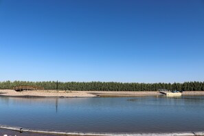 A calm lake with a wooden bridge and a dock.