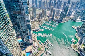 Un edificio alto con un puerto deportivo y barcos.