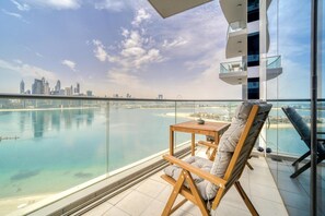 A balcony with a view of a city skyline and a body of water. - Lush Sea View Living w/ Private Beach at the Palm (Dubai)