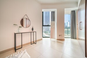 Ein modernes Interieur mit einer Konsole, einem Spiegel und Blick auf eine Stadtlandschaft durch ein großes Fenster.
