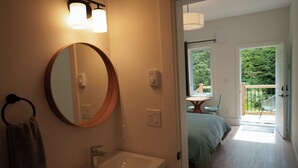 Une salle de bain avec un lavabo, un miroir et un porte-serviettes.