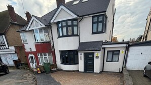 Una casa residenziale con vialetto lastricato, garage e un piccolo giardino.