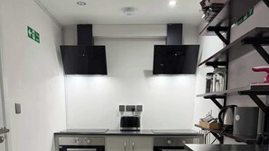 Una cucina moderna con un forno doppio, un tostapane e una macchina per il caffè.
