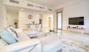 Ein modernes Wohnzimmer mit einer Couch, einem Couchtisch und einem Fernseher.