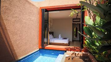Un espace piscine privé avec une chambre visible à travers une porte ouverte.