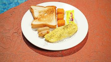 Une assiette contenant des tranches de pain grillé, des saucisses et un œuf au plat, le tout posé sur une surface orange texturée.