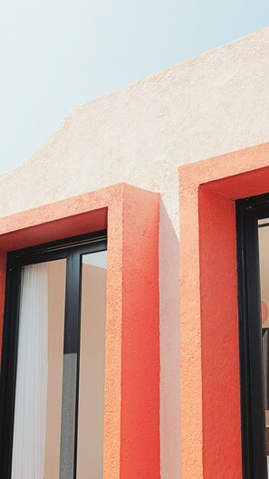 A building facade with a textured surface and a window with a white blind. - Soocha Villas (Yogyakarta)