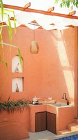 Un baño moderno con lavamanos integrado, una lámpara colgante y un estante pequeño con adornos.