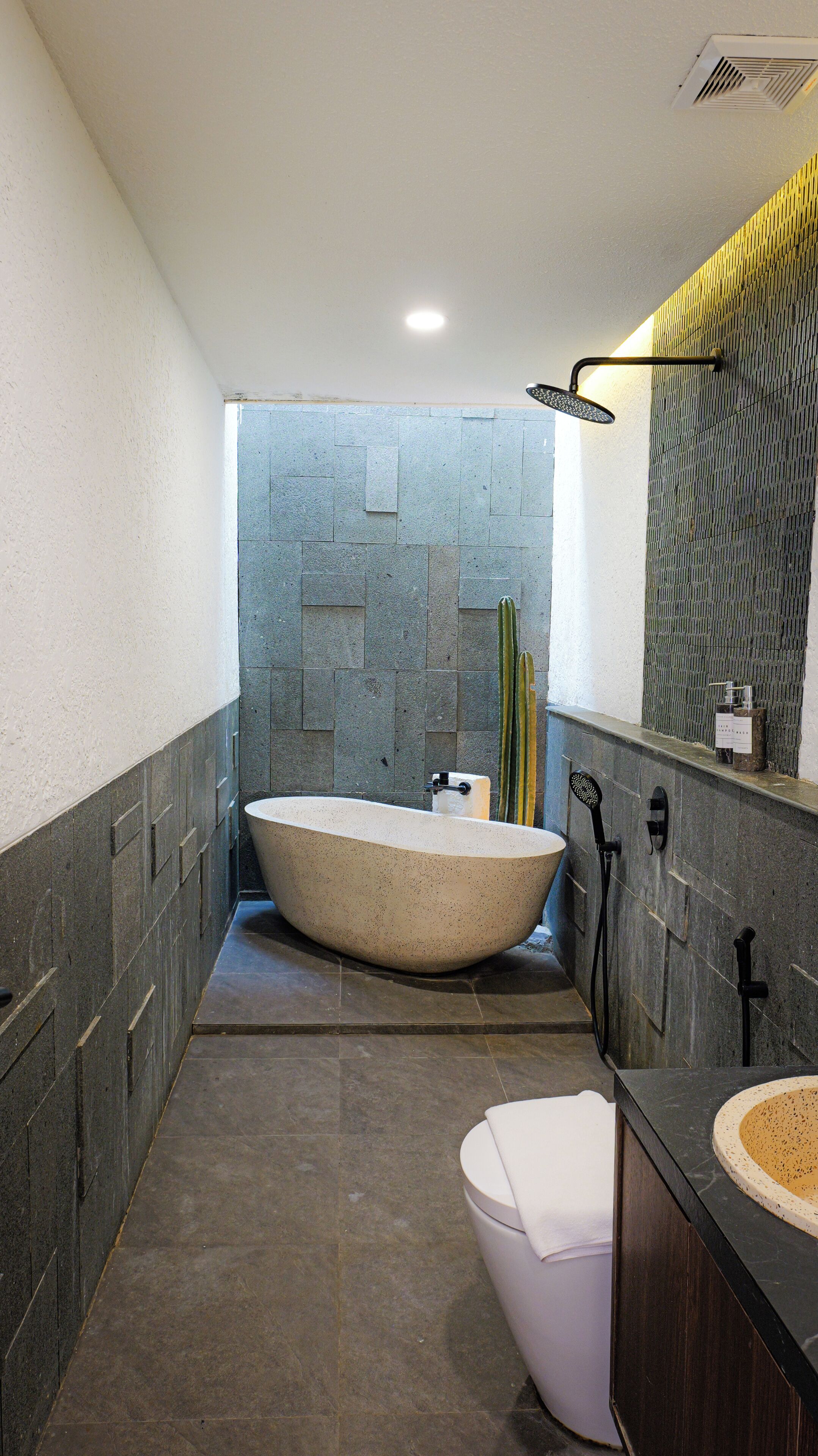 A modern bathroom with a freestanding bathtub, a toilet, and a sink.