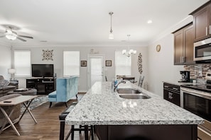 A modern kitchen with granite countertops, stainless steel appliances, and a central island with a sink. - Modern Dallas Retreat ~ Spacious 3BR + 2.5BA (Dallas)