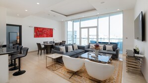 Ein modernes Wohnzimmer mit Sofa, Sesseln, einem Couchtisch und einem Essbereich.