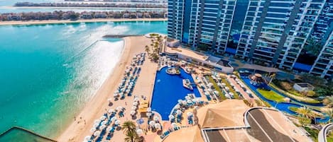 Resort com piscina grande, área de praia e vários edifícios.