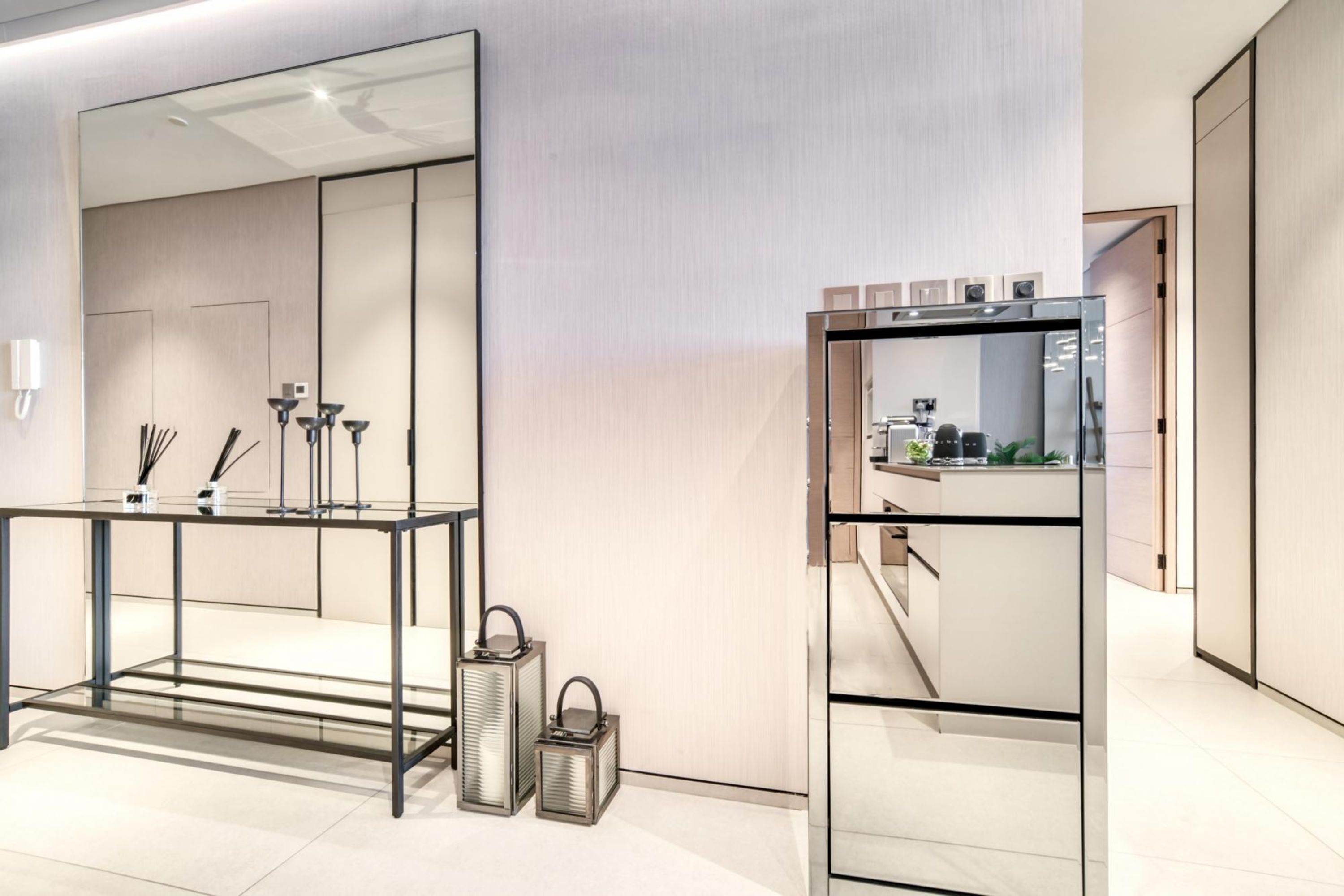 Un bagno moderno con un mobile lavabo in vetro, uno specchio grande e un lavandino.