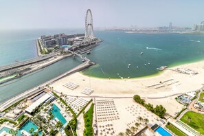 A coastal resort with a beach, a large Ferris wheel, and a marina. - Picturesque Balcony and Beach Haven at Address JBR (Dubai)