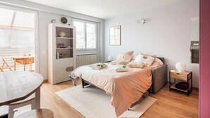 Een slaapkamer met een bed, nachtkastje en raam.