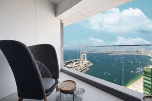 Un balcón con vistas a una ciudad costera, que incluye un puente destacado y un puerto deportivo.