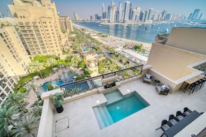 A rooftop pool with a view of a city skyline and a marina. - Modern 3BR Palm Penthouse w/ Private Plunge Pool (Dubai)