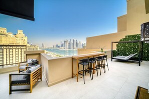 Ein Balkon mit Stadtblick, ein Barbereich und eine Lounge mit Aussicht.